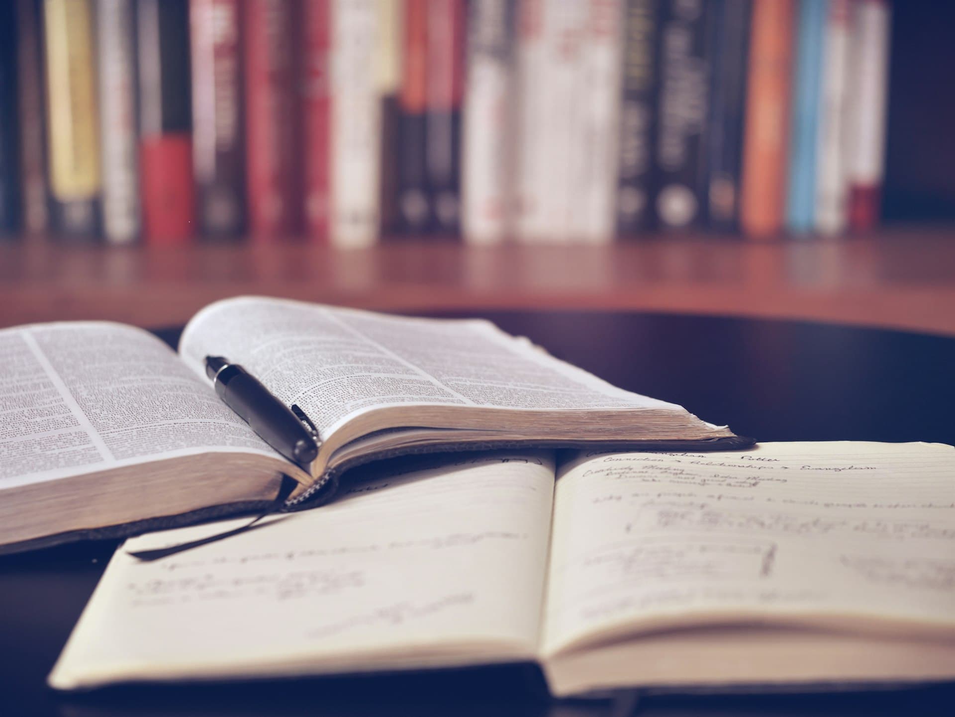 Open books and a notebook on a desk