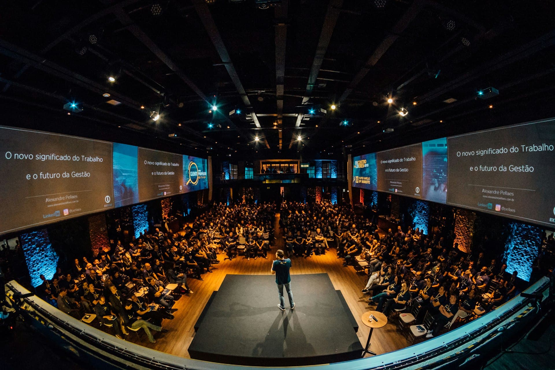 Speaker presenting on stage to a full audience